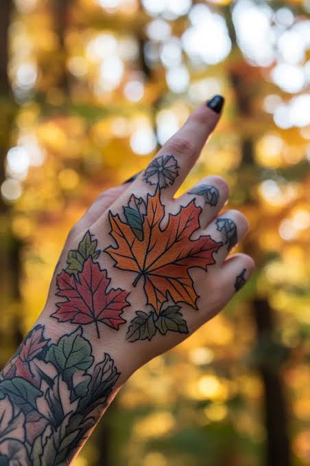 A bold orange maple leaf with smaller red and green leaves covers the hand and wrist.