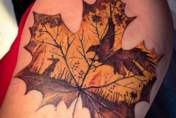 A glowing maple leaf frames a deer and woodland scene on the upper arm.