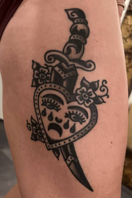 Crying heart pierced by a dagger with bold lines and small floral accents