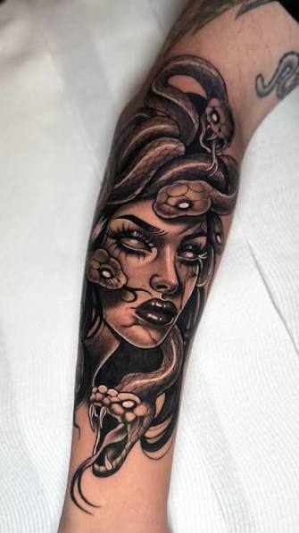 Medusa portrait with twisting snakes and a goat skull flowing down the forearm