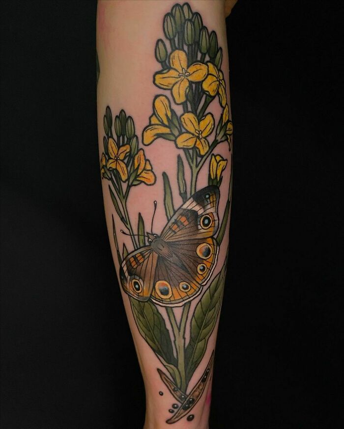 Butterfly with bold eye spots among yellow flowers on the calf and ankle