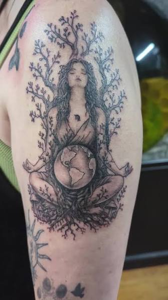Seated woman holding the Earth in her lap among shaded branches and roots