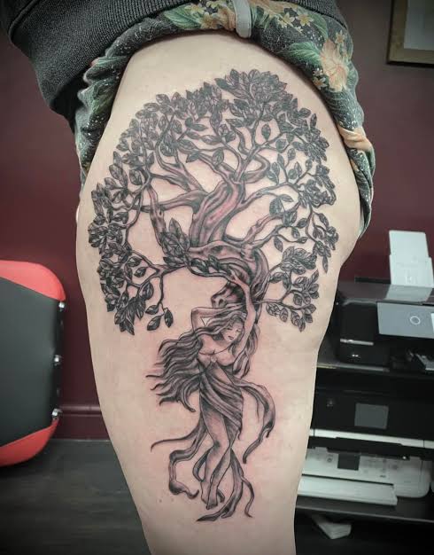 Woman's figure woven into a tree trunk and roots, with leaves spreading across the upper thigh