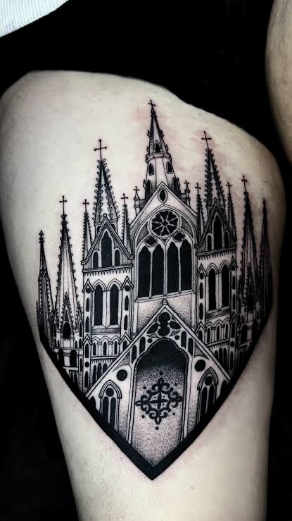 Shield shaped Gothic cathedral tattoo with sharp spires and deep black arches on the thigh