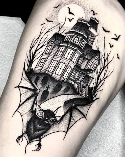 Dotwork bat haunted house tattoo on the thigh shows a fanged bat tearing through webs under a moonlit mansion.