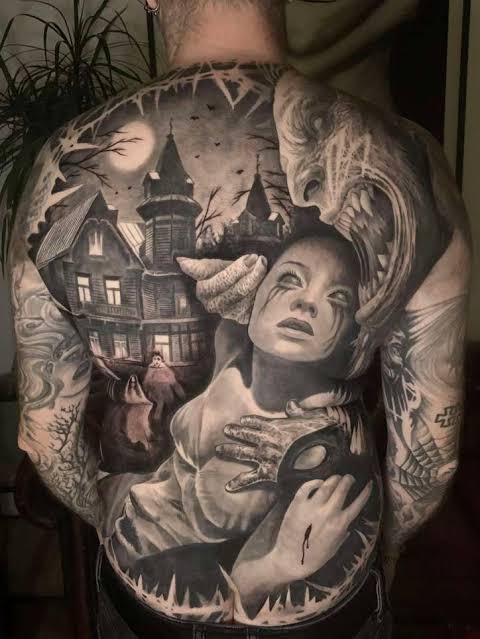 Horror movie mashup back tattoo blends a crying woman, a snarling creature, and a moonlit haunted house into one scene.