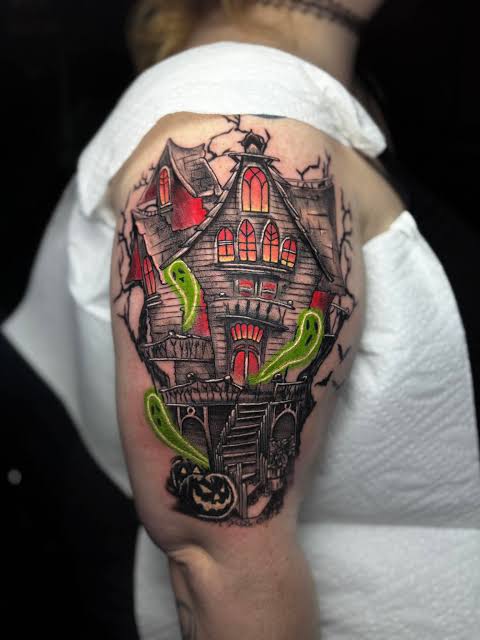 Neon green ghosts haunted house sleeve tattoo shows ghosts drifting from windows of a crooked mansion with warm lighting.