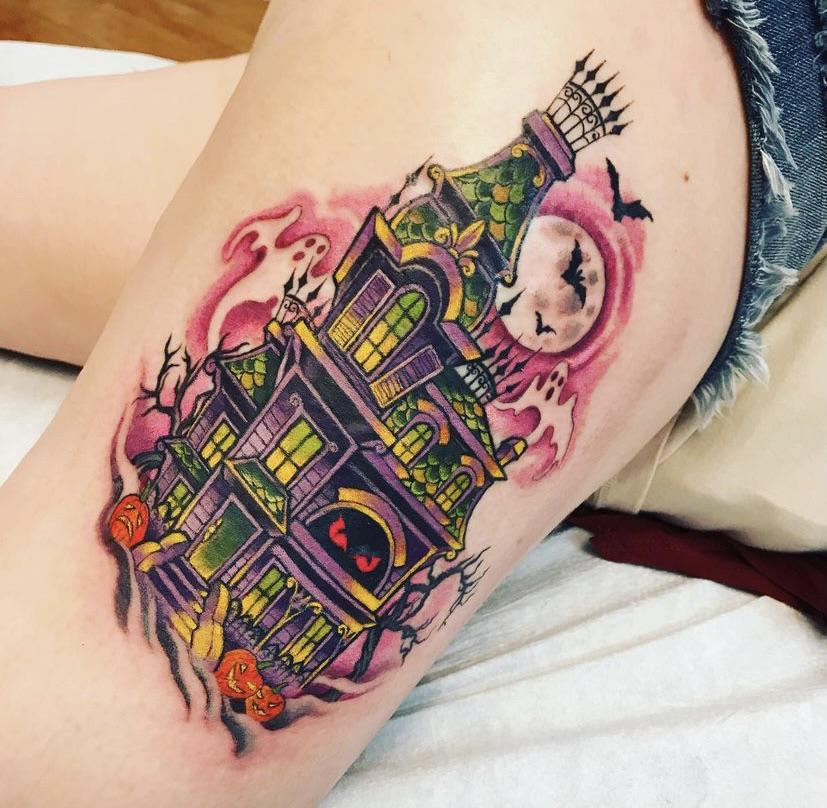 Neon haunted house tattoo on the thigh shows green scales, purple walls, and a glowing red eyed door.