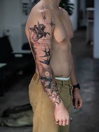 Floral tattoo sleeve extending from shoulder to hand with a skull near the wrist.