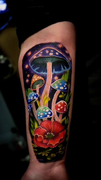Blue mushroom rising above red spotted caps and a large red flower along the forearm.