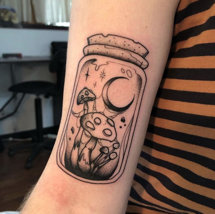 Corked glass jar holding a crescent moon, tiny mushrooms, and stars on the inner arm.