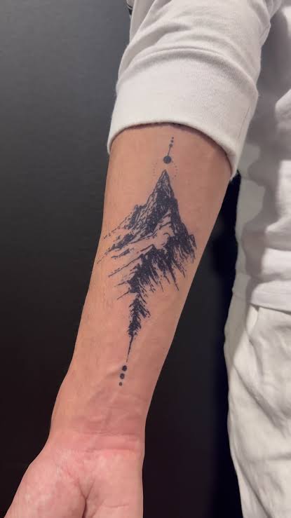 Bold sketch of a sharp mountain peak running along the inner forearm