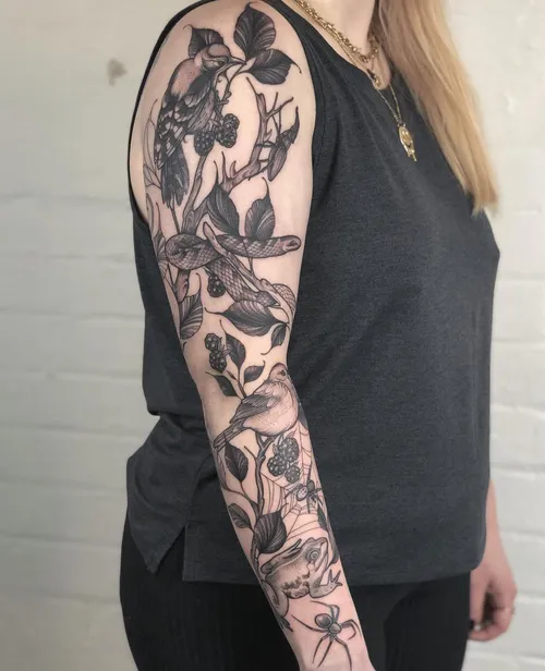 Woodland birds perch among berries and leaves, with black and gray branches winding down the arm.