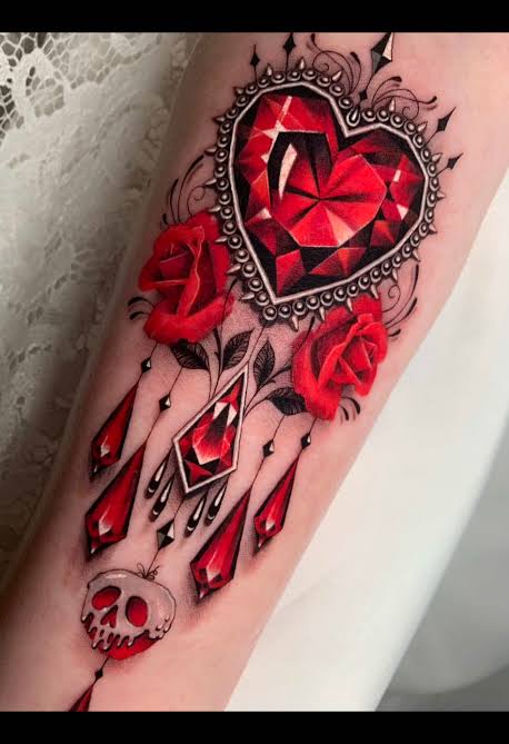 Ruby heart framed by red roses, crystal drops, and a small skull on the forearm