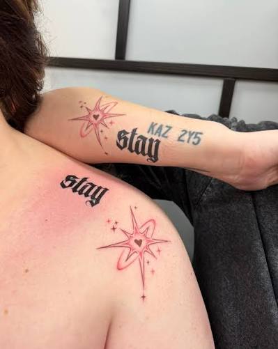 Bold gothic Stay lettering paired with pink heart shaped stars on the shoulder and forearm