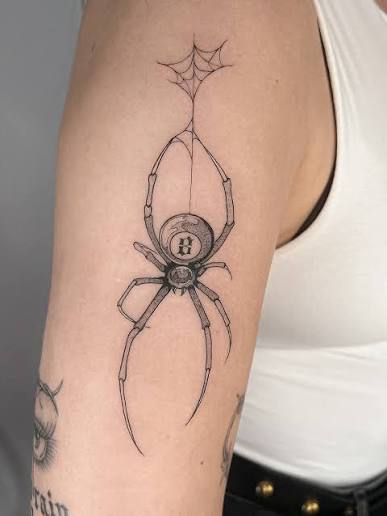 Fine line widow spider tattoo with a thin web tether on the upper arm.