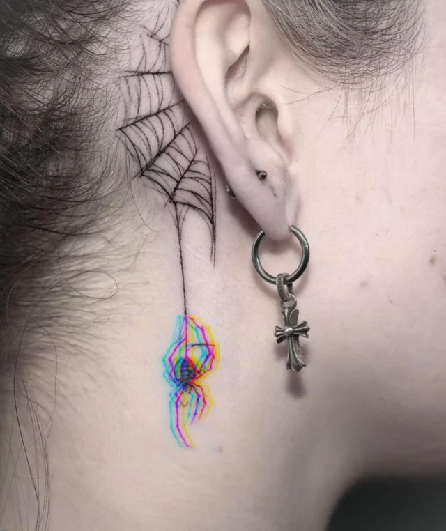 Rainbow glitch style spider dropping from a web tattoo behind the ear.