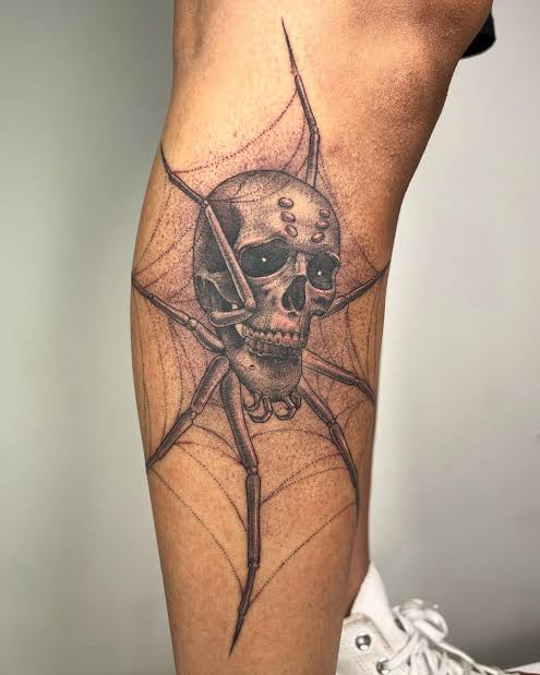 Skull and spider hybrid design with dotted shading wrapped in a torn web on the calf.