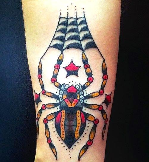 Traditional spider tattoo in orange and red with beaded legs on a checkered web, forearm.