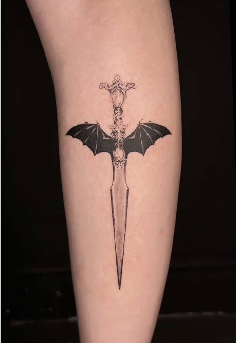 Slim gothic dagger with dark bat wings and ornate details running down the forearm