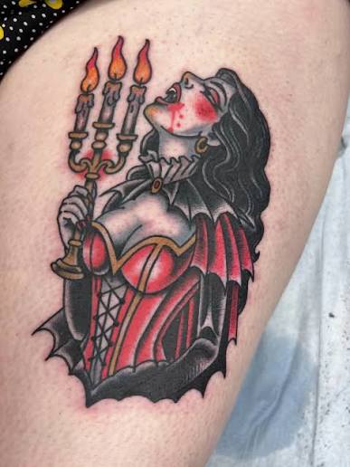 Bloodstained vampire countess beside glowing candles in a rich gothic thigh design