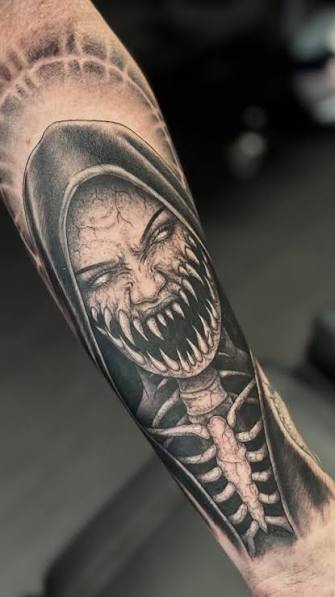 Hooded vampire nun baring her teeth in a shaded forearm design