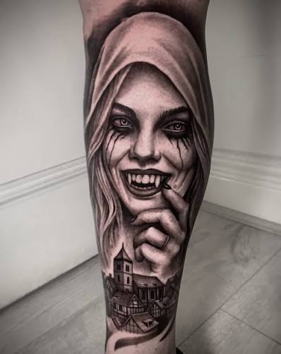 Fanged woman looming above a shadowy castle in an eerie calf tattoo