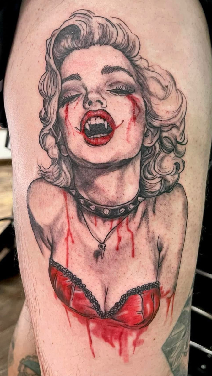 Marilyn Monroe shown as a vicious vampire with smeared blood and a red corset on the thigh